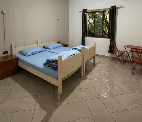 a bedroom with a bed and a table and a window at Hostel Osho in Tirana