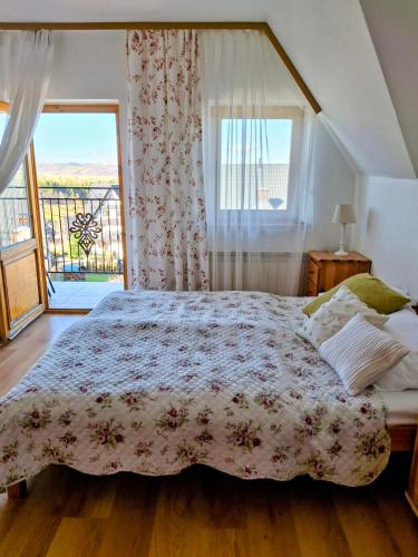 a bedroom with a bed and a large window at Pokoje u Hanki in Murzasichle