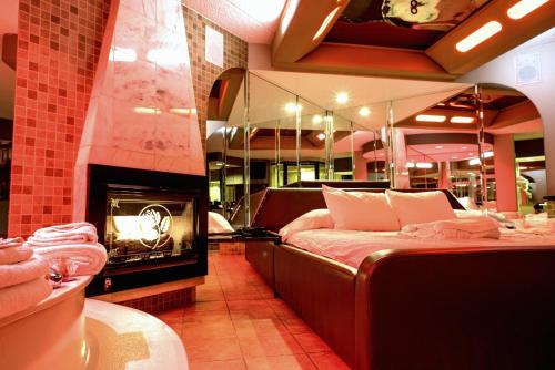 a hotel room with a bed and a fireplace at Essence Suites in Orland Park