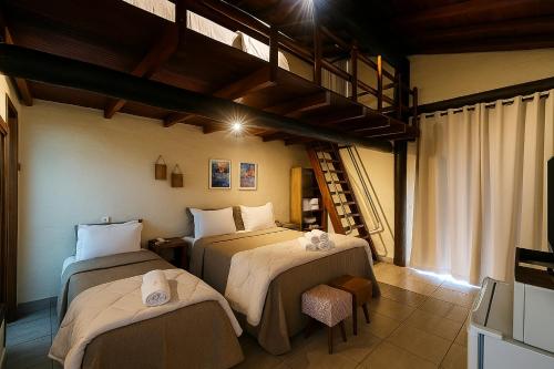 a bedroom with two beds and a loft at Pousada A Mata que Canta in Socorro
