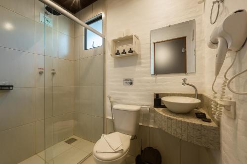 a bathroom with a toilet and a sink and a shower at Pousada A Mata que Canta in Socorro