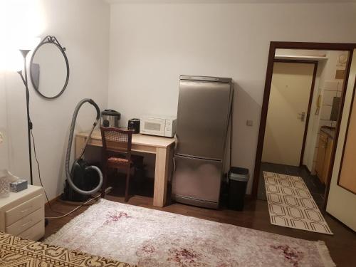 a kitchen with a refrigerator and a table with a mirror at Graeff sweet apartment in Cologne