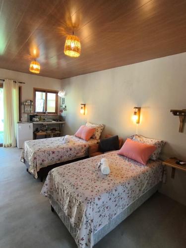a bedroom with two beds and two lights on the wall at Há Mar Chalés Corumbau in Prado