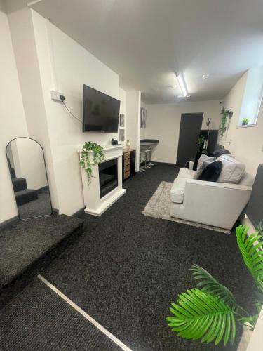 a living room with a white couch and a tv at Allon Manor in Hull