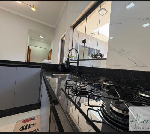 a kitchen with a stove and a counter top at Cantinho do Descanso in Peruíbe