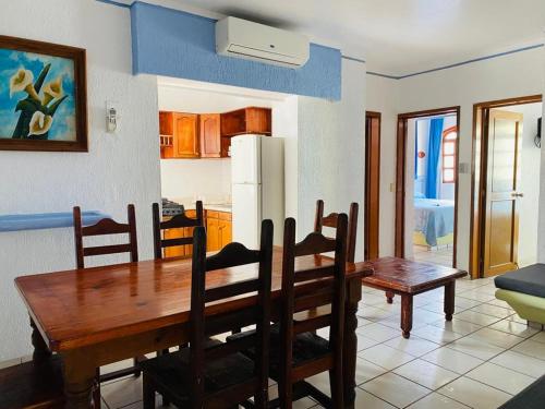 a kitchen and dining room with a wooden table and chairs at Hotel Jacqueline in Rincon de Guayabitos