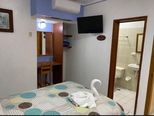 a room with a bed with a swan on it at Hotel Jacqueline in Rincon de Guayabitos