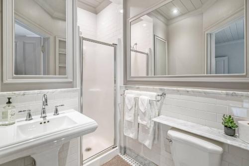 a white bathroom with a sink and a mirror at Guestroom in Old Town | Steps to Lake & Everything in Niagara on the Lake
