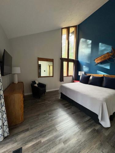 a bedroom with a large bed and a blue wall at Mountain Villas Condo Retreat for 12 in Boyne Falls