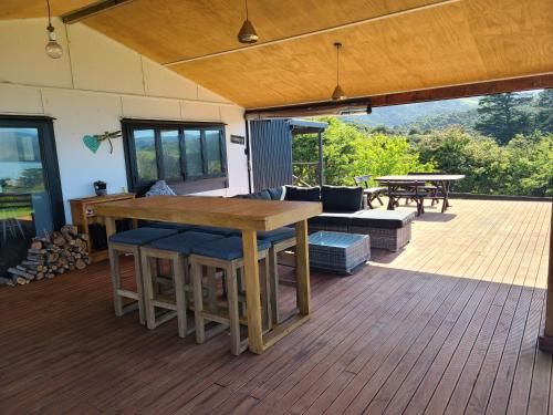 a wooden deck with a table and chairs on it at Te Papatapu Retreat in Raglan