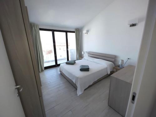 een slaapkamer met een wit bed en een groot raam bij Atemberaubendes Familien Penthouse Mit Meerblick in Cannigione