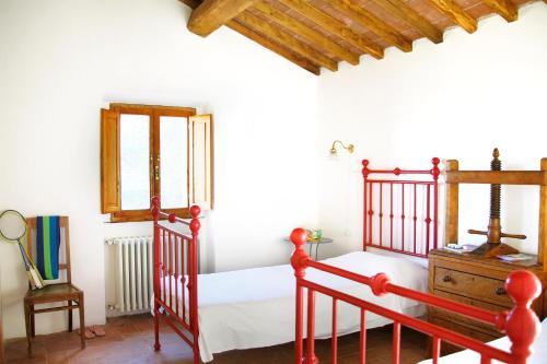 a bedroom with a red bed and a dresser at Casa Delle Aque in Montecatini Val di Cecina