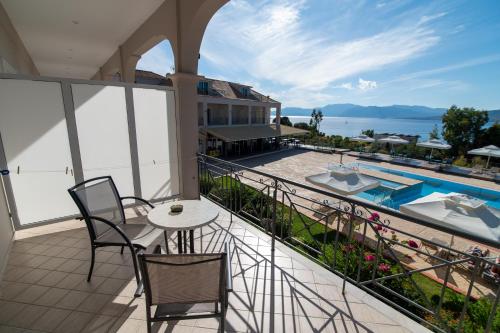 a balcony with a table and chairs and a swimming pool at Elektra Hotel in Paleros