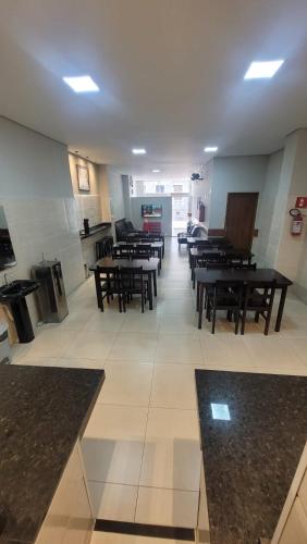 a room with tables and benches in a building at Hotel Aliança in Limeira