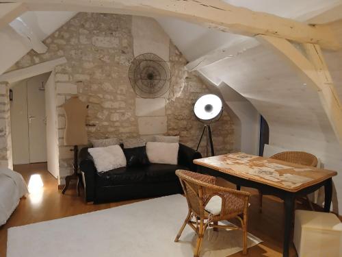 een woonkamer met een zwarte bank en een tafel bij La parenthèse bucolique in Sepmes
