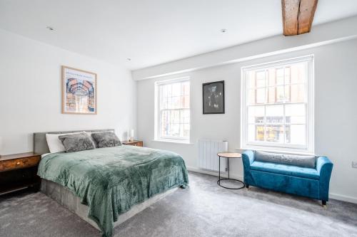 a bedroom with a bed and a blue chair at Historic Flat by Liverpool Street in London