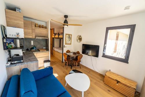 a living room with a blue couch and a table at Studio à Vallouise-Pelvoux - Puy Saint Vincent, nature, rando et ski in Vallouise