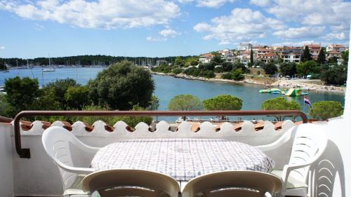 a table on a balcony with a view of a river at Suran Apartments in Pula