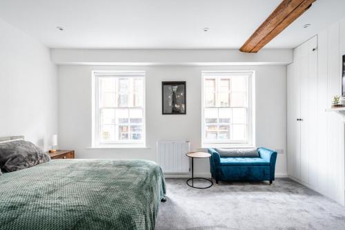 a bedroom with a bed and a blue chair at Historic Flat by Liverpool Street in London