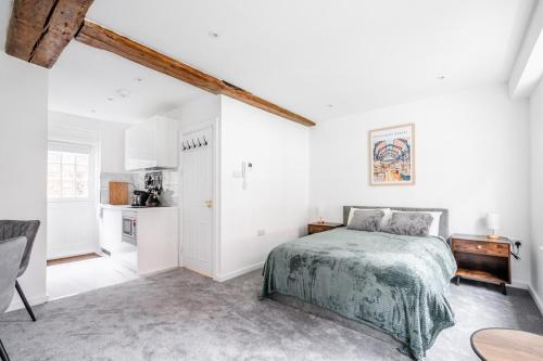 a white bedroom with a bed and a kitchen at Historic Flat by Liverpool Street in London