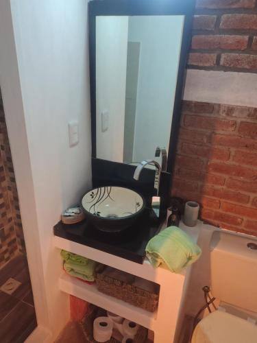 a bathroom with a sink and a mirror at Vinoteca cerro in Piriápolis