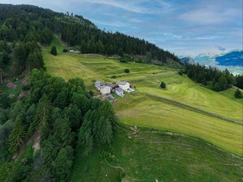 uma vista aérea de uma casa num campo verde em Monte Campell Dasura em Poschiavo