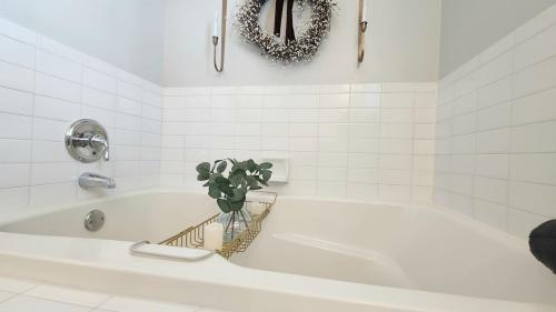 La salle de bains est pourvue d'une baignoire blanche avec une plante. dans l'établissement Royal Pearl AC - Bay Views, Close to Casinos!, à Atlantic City