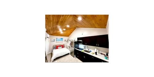 a small room with a bed and a kitchen at SoSo Design District Haven Charming Historic Retreat in West Palm Beach