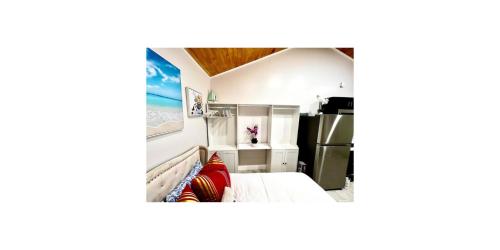 a small room with a bed and a refrigerator at SoSo Design District Haven Charming Historic Retreat in West Palm Beach