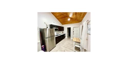 a kitchen with a stainless steel refrigerator and wooden ceilings at SoSo Design District Haven Charming Historic Retreat in West Palm Beach