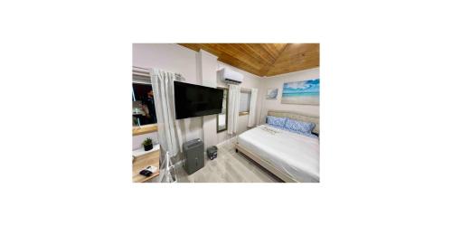 Camera con letto e TV a schermo piatto. di SoSo Design District Haven Charming Historic Retreat a West Palm Beach