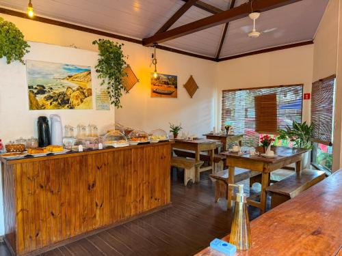 a dining room with wooden tables and benches at Pousada João Maria in Trancoso