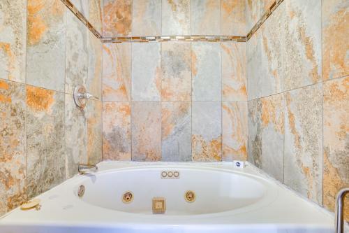 4 Mi to Southlake Town Sq Peaceful Gated Retreat! في Keller: حوض استحمام في حمام مزين بالبلاط