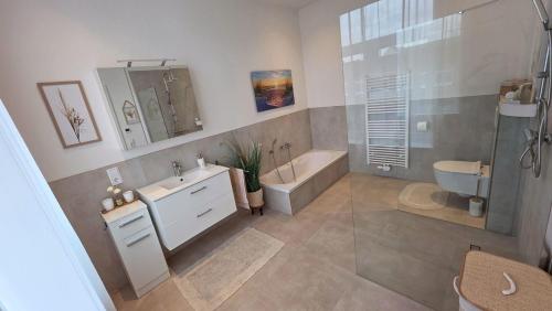 a bathroom with a tub and a sink and a toilet at Amadeus Loft in Wilhelmshaven