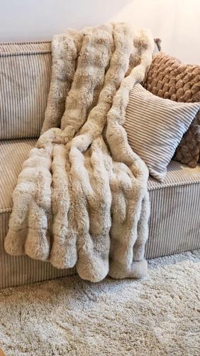 a faux fur blanket sitting on top of a couch at Amadeus Loft in Wilhelmshaven