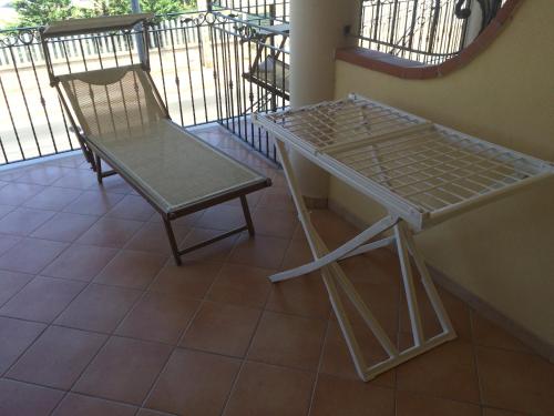a table and a chair on a balcony at Summer Holidays Apartments in Foce Varano