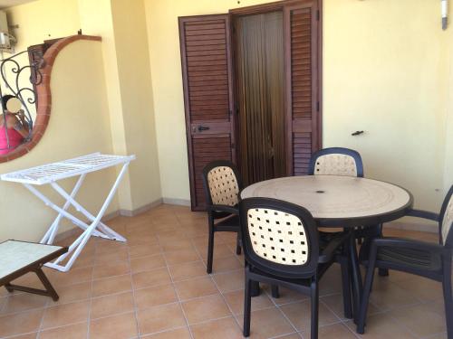 a table and chairs in a room with a door at Summer Holidays Apartments in Foce Varano