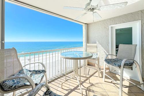 a balcony with chairs and a table and a view of the ocean at Beachfront Bliss! 1800 sq ft Spacious 3BR Sleeps 12 - Oceans 9D in Gulf Shores