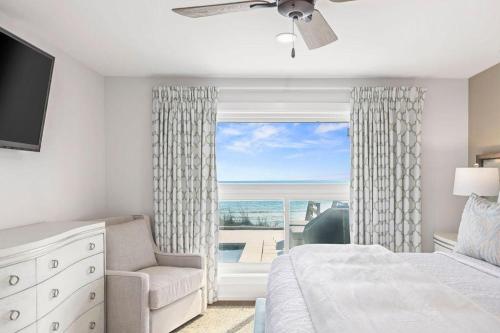 a bedroom with a bed and a chair and a window at Seaside Retreat in Santa Rosa Beach