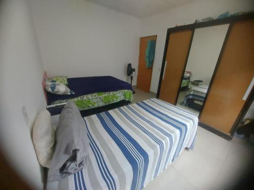 - une petite chambre avec 2 lits et un miroir dans l'établissement Casa de alto padrao na beira do lago Corumba IV, à Brasilia