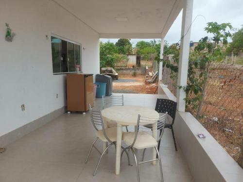 une table et des chaises sur le balcon d'une maison dans l'établissement Casa de alto padrao na beira do lago Corumba IV, à Brasilia