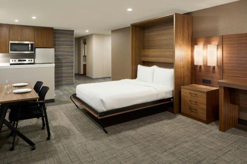 a hotel room with a bed and a desk and a kitchen at Residence Inn by Marriott Laval in Laval