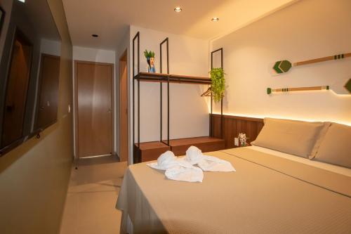 una camera da letto con un letto con asciugamani sopra di Triplex 3 Suítes Piscina e Hidro para até 12 pessoas a Tatuamunha