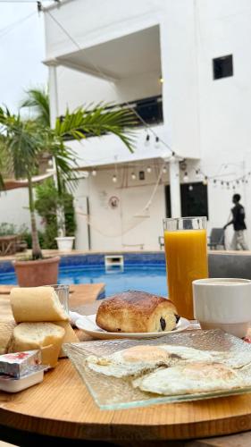un tavolo con un piatto di cibo e un bicchiere di succo d'arancia di Jade guest House a Dakar
