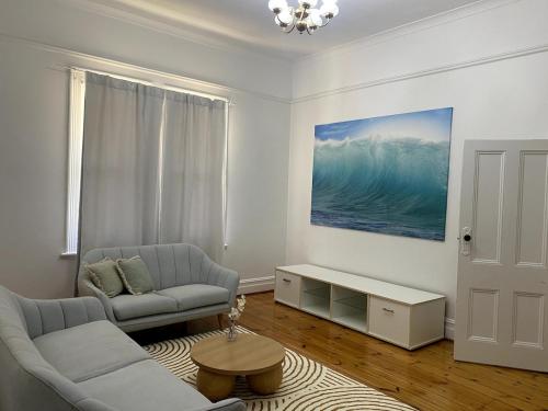 a living room with a couch and a table at Glenelg - Charmer in Glenelg