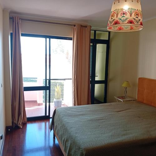 a bedroom with a bed and a large window at Varandas do Funchal Apartment in Funchal
