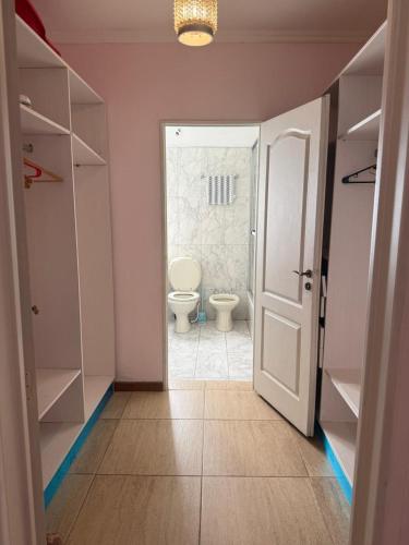 a bathroom with a toilet and a bathroom with a door at La Bendita in Posadas