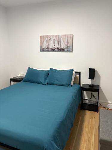 a bedroom with a blue bed and two tables at Maison d edouard in Saint-Antonin