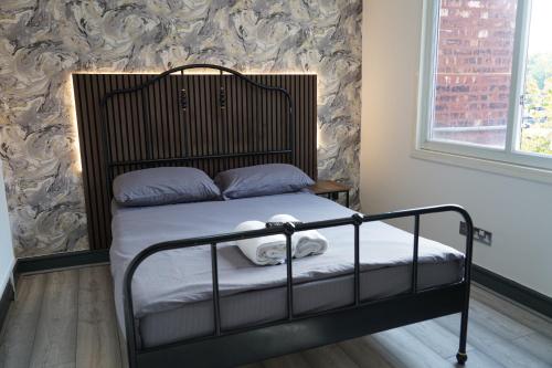 マンチェスターにあるHills View Apartmentsの小さなベッドルーム(黒枠のベッド1台付)