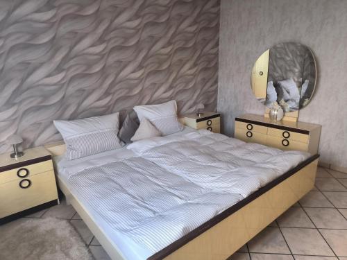 Un dormitorio con una cama grande y un espejo. en Marisa's Sauerlandträumchen, en Brilon